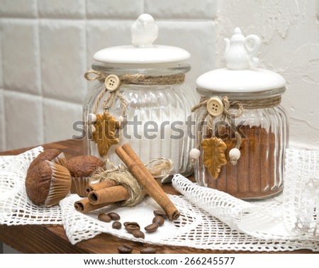 still life, decorative jars for bulk products with cupcakes and cinnamon on a background of lace