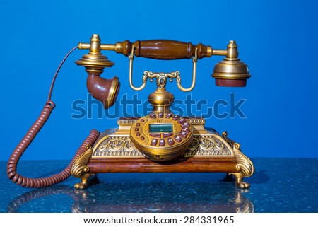 old phone on a granite pedestal and blue background. remake