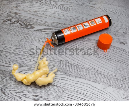 construction foam on the background of the wooden flooring. polyurethane, background, tool