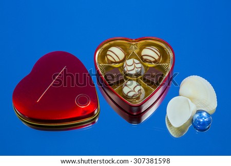 candy, metal box, sea shell lying on the mirror. fragment, still life, wallpaper