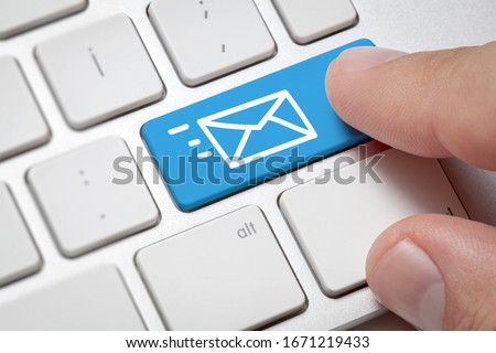 Online Communication concept: Macro male hand pressing computer key with e-mail illustration. Communication on internet globally concept.