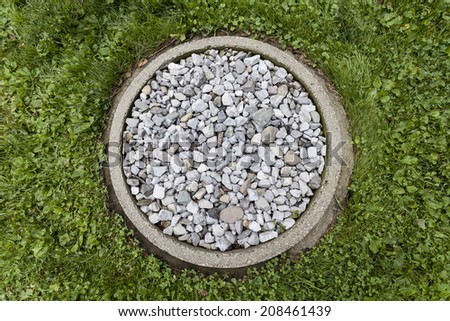 A ring of stones in the garden to catch the rain water from the drip rail