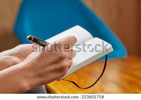 Woman writing in a book with a fountain pen
