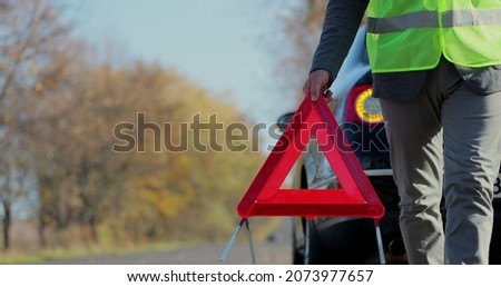 Similar – Foto Bild Fahrer stellt rotes Dreieck in der Nähe des kaputten Autos auf