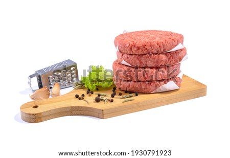 Burger patties stacked on the table. Raw beef patties isolated on yellow background.
