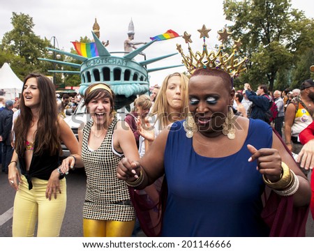 BERLIN,GERMANY - JUNE 21,2014:Christopher Street Day.Crowd of people Participate in the parade celebrates gays,lesbians and bisexuals.Prominent in the image a transgender dressed as Statue of Liberty.