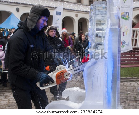 SZCZECIN, POLAND -  DECEMBER 6, 2014: Unidentified man with chainsaw Stihl, creating artwork out of the block of ice. Stihl is a German manufacturer of chainsaws and other power equipment.