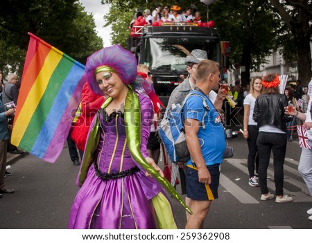 BERLIN, GERMANY - JUNE 21, 2014:Christopher Street Day.Crowd of people Participate in the parade celebrates gays, lesbians, and trans-genders. Prominent in the image, elaborately dressed participant.