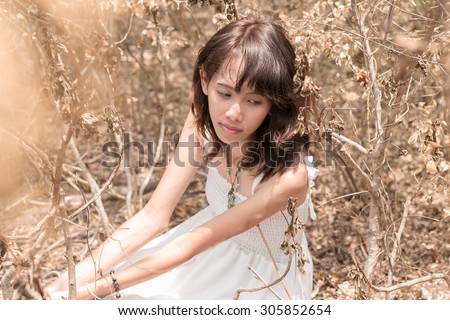 asia women white dresses lonely and isolated in deserted forest - selective focus point at face,tone image wasteful