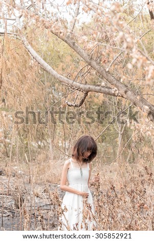 asia women white dresses lonely and isolated in deserted forest - selective focus point at face,tone image wasteful