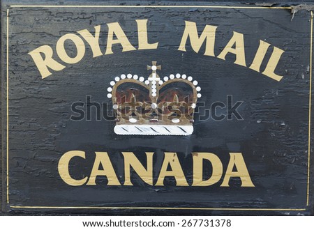 A black Royal Mail Canada sign with gold lettering with a crown in the center.