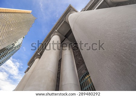 A low angle view of round concrete columns outside Union Station in downtown Toronto Ontario Canada which contrasts the buildings opposite.