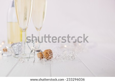 Champagne with cork and wired chair on white wooden table