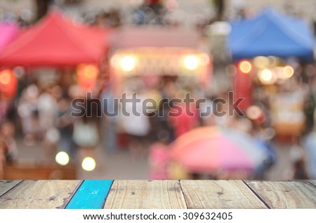 Blur people shopping at local street market with old empty table wood abstract background.