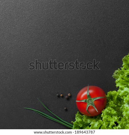 red tomato with green salad on black