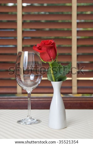 wineglass and rose on the table