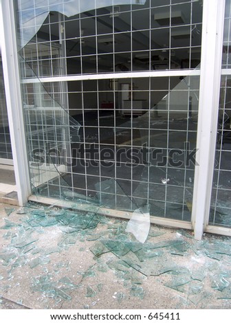 Broken shop window with security screen.