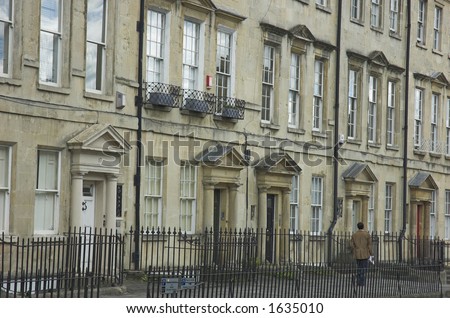 A classic Georgian street facade in Bath, England. Cool guy strolling past.