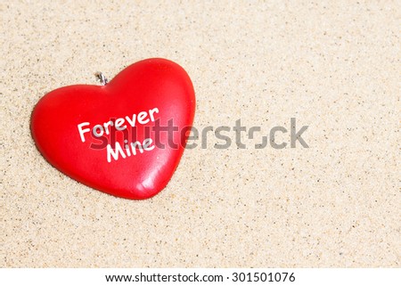Heart on the sand  background.  Love wallpaper, greeting card. Forever Mine inscription.