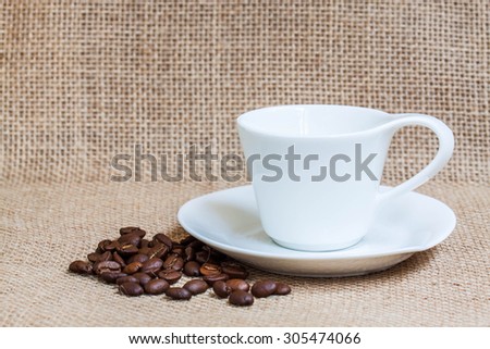 Coffee  wallpaper, background, grains of coffee plant and  white coffee set  on  burlap, sackcloth texture.