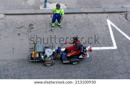Workers put road marking machine with manual control in Sofia, Bulgaria August 26, 2014