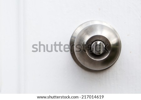 Aluminum door knob on the white door skin.