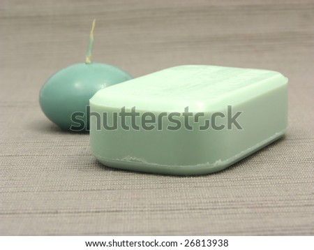 Green soap and green candle on a  gray background