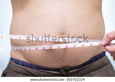 Fat asian man use waist measure for measure his belly. white background