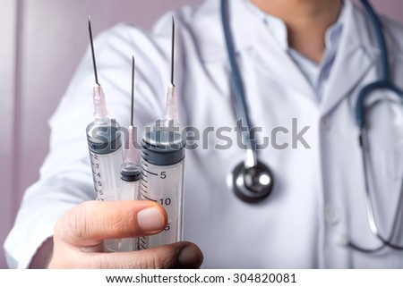 Doctor with syringes, ,doctor holding syringe  and stretch out.