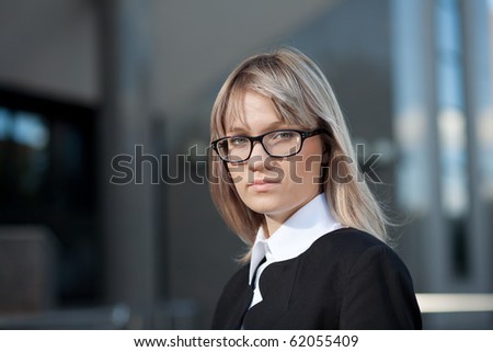 Young businesswoman standing in front of office building