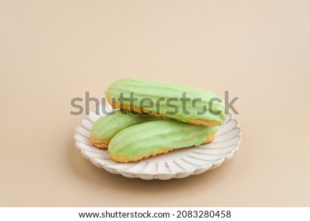 Traditional French dessert. Sweet and colorful eclairs with chocolate glaze. Served in white plate on brown background, copy space.
 ストックフォト © 