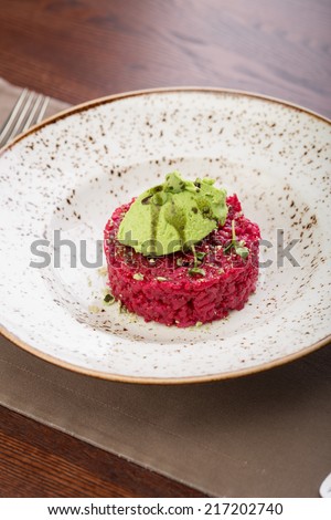 Beetroot risotto with green peas sorbet on the table at restaurant