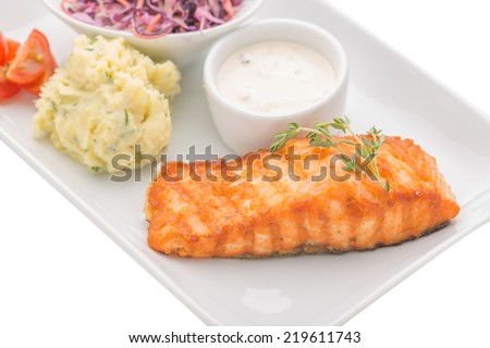 Grilled salmon steak with mashed potatoes and cole slaw salad isolated on white background. Close up