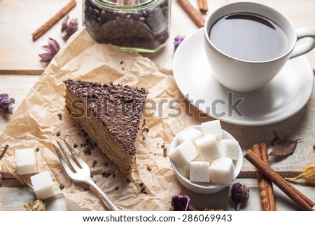 Chocolate cake and cup of coffee on wooden background
