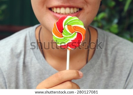 Young woman eating candy at the park.