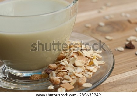 Oat flaks on a wooden spoon and glass of milk. ,Vintage style