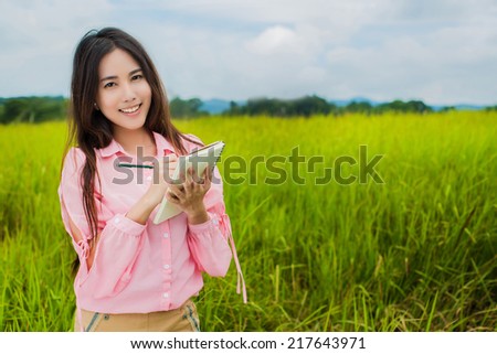Asian woman holding a notebook to take notes