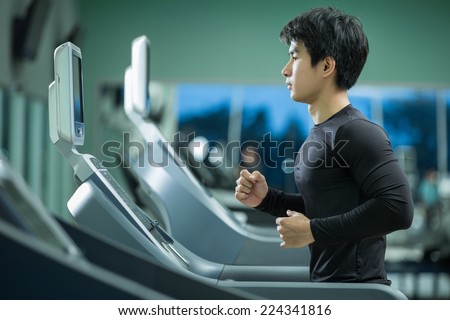 Asian man running on the treadmill in the gym