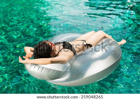 Woman relaxing on a swimming ring, swimming pool. Summer Holiday