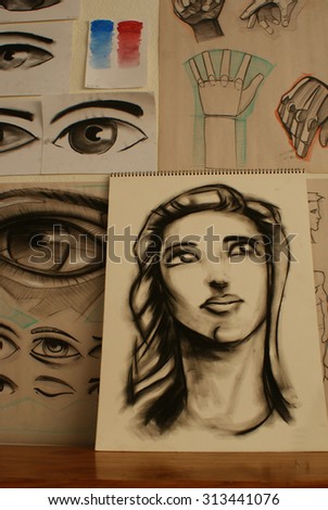 Photograph some hand drawn sketches of a womans face hands and eyes