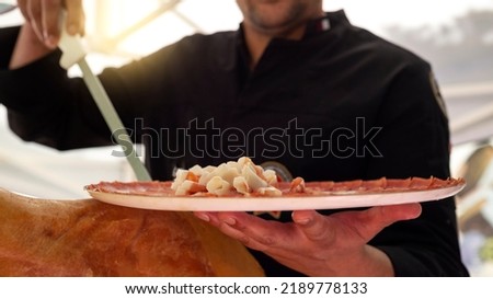A chef ham cutter with his knife, showing a freshly cut plate. Concept of Spanish culture Foto stock © 