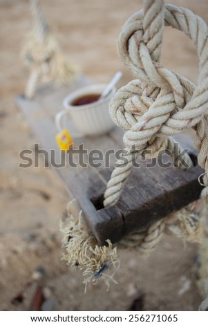 Wooden swing with tea cup