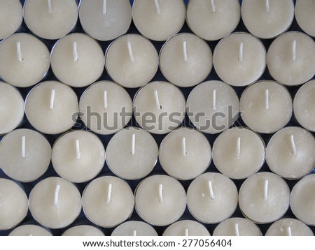 Rows of white wax tea light candles