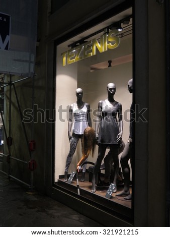 PADUA, ITALY - CIRCA JULY 2014: stylish fashion shop in the city centre displaying high couture clothes, for which Italy is famous worldwide, with shop assistant vacuum cleaning