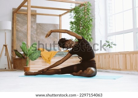 Similar – Image, Stock Photo Slender barefooted woman stretching body in bound angle pose in contemporary studio