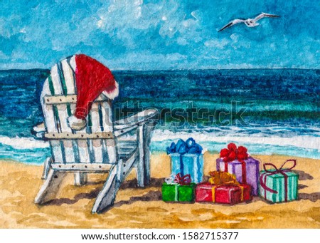 Christmas presents on the beach. White wooden chair lounge with Santa hat and gift boxes at the sea coast.
