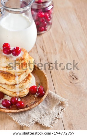 Russian quark pancakes with condensed milk and cranberry. Selective focus. Copy space background.