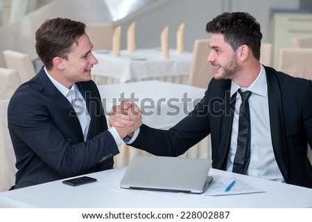 Good job. Successful and motivated businessmen are shaking hands of his business partner approving the good deal