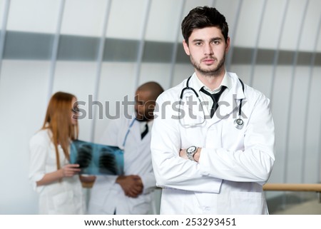 Portrait of a doctor of the therapist. Confident doctor is standing in the hospital in a white coat and thinking about patient and health