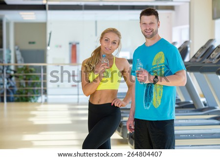 Proper sport shape. Couple of sportsmen, male and female, are having intensive training in a gym. Perfect athlete shape.